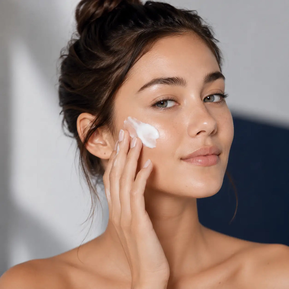 Hands lathering with cream suds over porcelain basin — cleanse